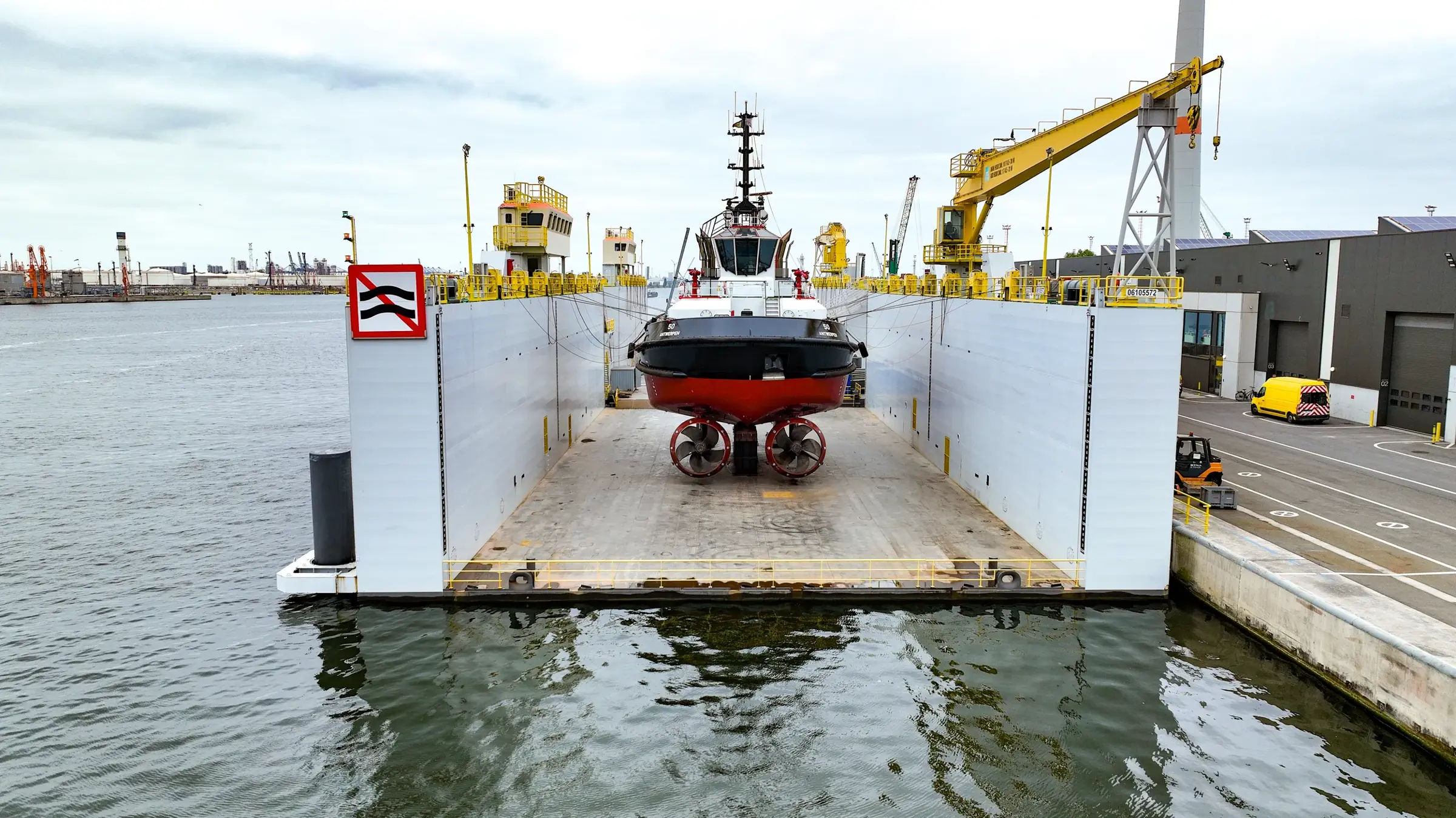 Een sleepboot ligt in een drijvend droogdok.