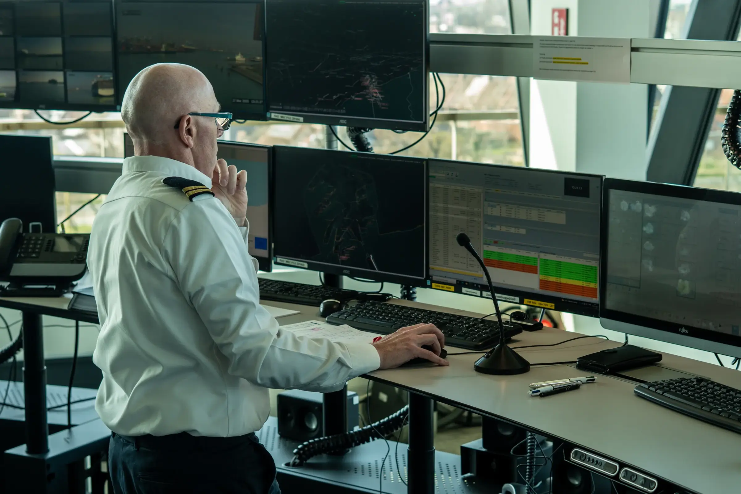 Een werknemer monitort de activiteiten in de haven aan de hand van hoogtechnologische systemen. 
