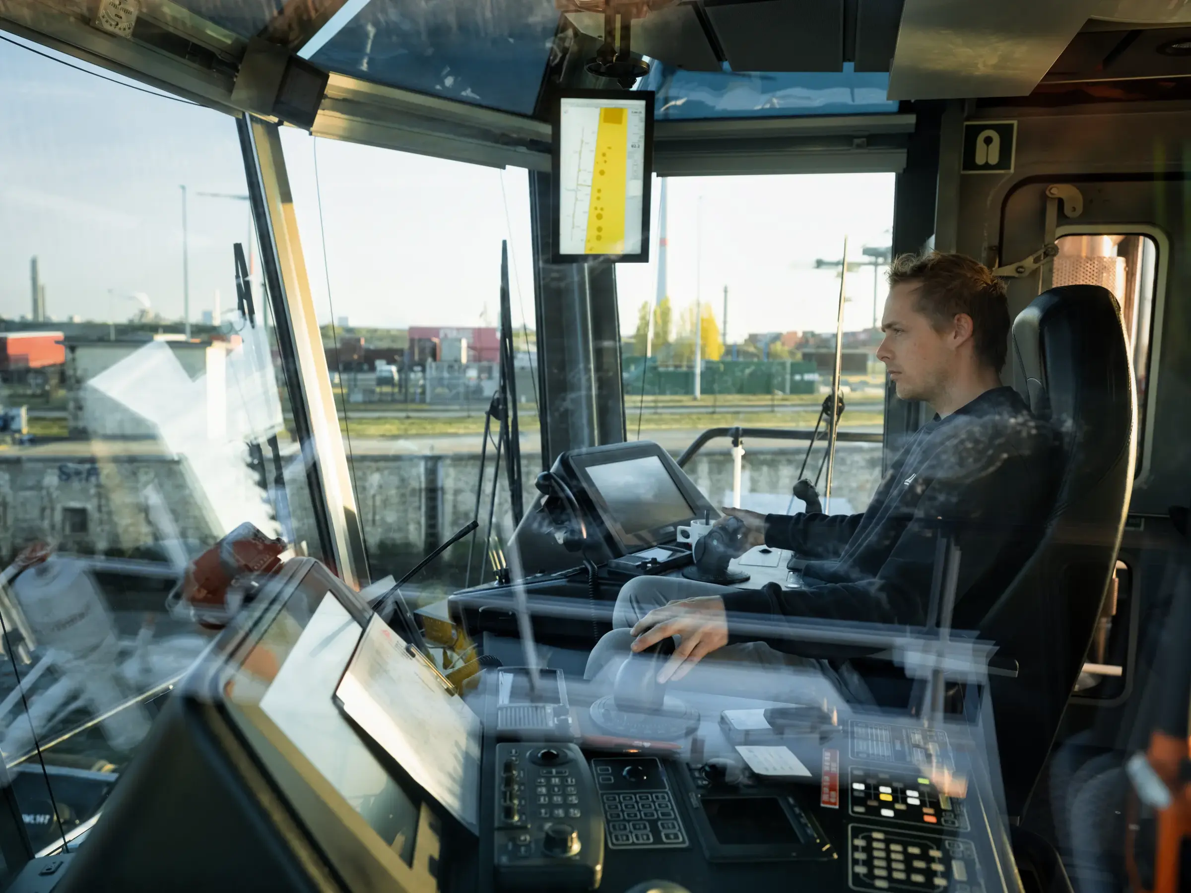 De kapitein van een sleepboot in zijn stuurhut.